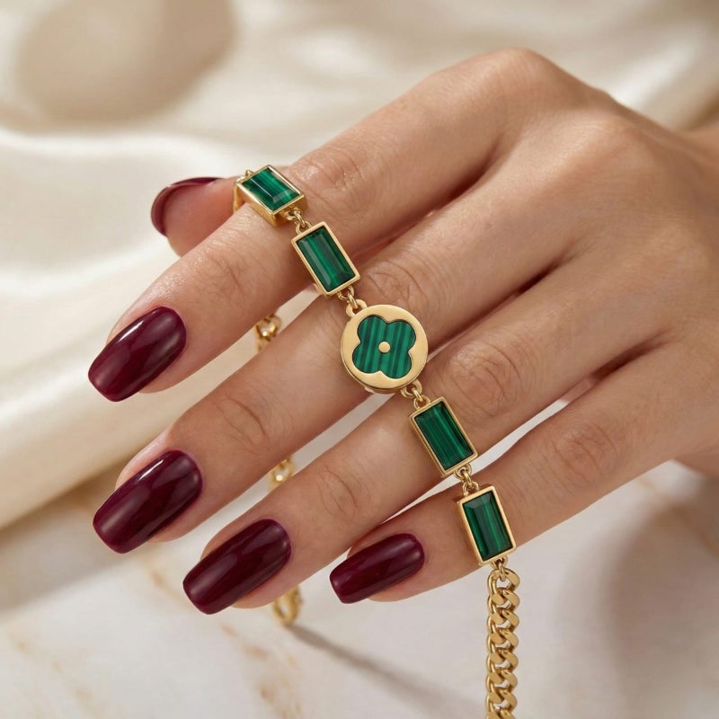 An elegant gold bracelet made of rust-resistant stainless steel, featuring a small, distinctive green flower at its center, adorned with green stones. It has an adjustable clasp for a perfect fit. - Image 4